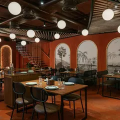 For the 'Chambal' restro-bar, I used a monochromatic palette of rustic red and exposed brick to create a warm, immersive dining experience. The design, including the globe pendant lights, evokes a sense of rustic celebration while maintaining a modern, open-plan layout.