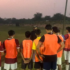 A coach gives a team talk during a break in training. These moments are crucial for reinforcing tactical instructions and keeping the team focused.