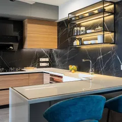 I love the drama of a bold kitchen. Here, the striking black marble backsplash and warm wood cabinetry create a sophisticated contrast, while the island with comfortable seating makes it an inviting social hub. This is a space designed for both cooking and conversation.