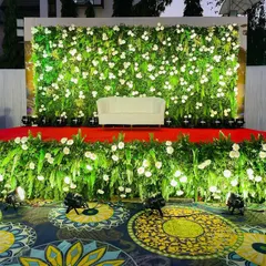 Even large events need beautiful photo opportunities. For this celebration, we created a lush floral stage with a wall of greenery and white flowers, providing a perfect backdrop for photos.