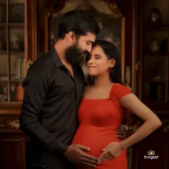 An intimate close-up of an expecting couple in a warm, classic setting. This type of shot focuses purely on the emotional connection and love between the partners.