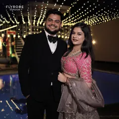 This happy couple is dressed perfectly for a reception or cocktail party. He looks dapper in a classic black tuxedo with a three-piece vest and bow tie.