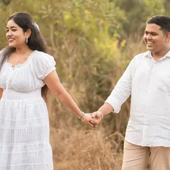 A candid shot of a couple holding hands and walking through a sunlit field. Their natural smiles and relaxed posture reflect the peaceful and easygoing nature of their relationship.