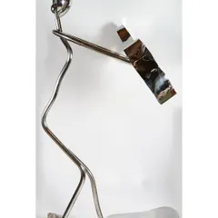 "Serenade in Steel," a sculpture capturing a musician lost in her melody. This abstract figure, crafted from steel rods and polished forms, embodies the harmony between rhythm and song.