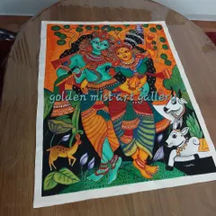 The completed Radha Krishna painting on a wooden table, showing the full composition with the cows and deer.