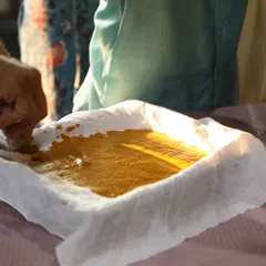 Preparing a natural yellow dye paste for a block printing session. This hands-on process is a key part of our workshops, where participants learn how colors are made from plants and minerals.