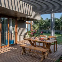 A perfect spot for an alfresco meal. I designed this wooden deck with a picnic-style table and bench, creating a relaxed and inviting outdoor dining area that connects directly to the home.
