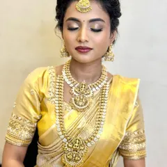 The eye makeup for this muhurtham look features soft, shimmery golds and a defined lash line, making the eyes stand out beautifully.