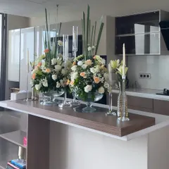 We turned the kitchen island into a beautiful focal point with two large glass bowls filled with lush arrangements of white and peach flowers. Tall, slim candles add height and a touch of elegance to the heart of the home.