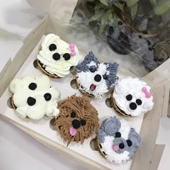 Another angle of the puppy cupcakes, showing the variety of breeds and details like little pink bows and tongues. These custom cupcakes are always a hit at parties.