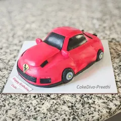 A carved Ferrari cake for a car enthusiast. I sculpted this from a rich cake base and covered it in red fondant, paying close attention to the car's sleek lines and details.