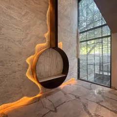 A wider view of the custom fireplace, showing its relationship to the double-height window and bookmatched marble flooring. The design is a testament to our process of turning complex sketches into reality.