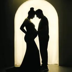 There is a special magic in silhouette portraits. This image focuses purely on the connection between the expecting parents, their shapes telling a story of love and anticipation against a warm, glowing archway in my studio.