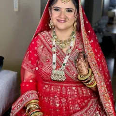 A truly royal bridal look. The combination of a bold red lehenga, intricate jewelry, and my signature glowing makeup with golden eyes creates a statement of pure grandeur.