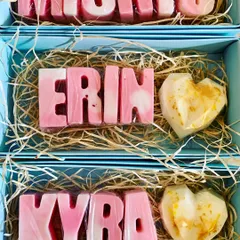 Elegant personalized name soaps in pastel pink and white, paired with a gold-dusted heart soap for a beautiful return gift.