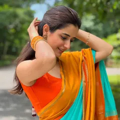 A candid shot of Ashika. The simple, clean lines of the sleeveless blouse make it a versatile piece that lets the saree be the hero.