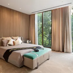 The master suite in our Punjabi Bagh project is a sanctuary designed for slow, luxe living. Expansive floor-to-ceiling windows invite the surrounding greenery indoors, while a fluted feature wall and understated materials create a serene, textural backdrop for rest and relaxation.