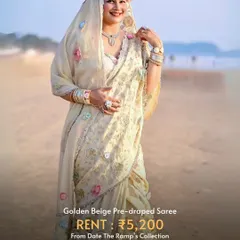 A beautiful golden beige pre-draped saree, perfect for a beach wedding or a daytime festive event.