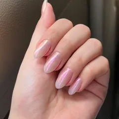 A beautiful example of a soft pink chrome finish on almond-shaped nails, giving off an iridescent, pearly glow.