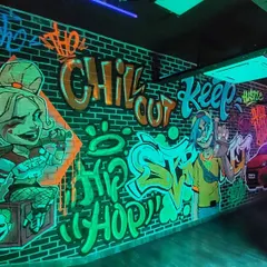 This UV-reactive mural was a dope project for a gaming lounge. The neon graffiti, featuring characters like Harley Quinn, comes alive under blacklight, creating an immersive, edgy atmosphere.