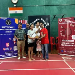 A winner from our 2024 in-house badminton tournament receiving her trophy. These events foster healthy competition and give our players valuable match experience in a supportive environment.
