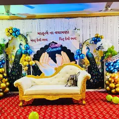 We create beautiful and culturally rich setups for baby showers. This stage features traditional peacock motifs, elegant seating for the mother to be, and a custom backdrop with blessings written in Gujarati, all framed by vibrant balloon arrangements.