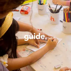 Our role is not to fill a pail, but to light a fire. Here, a teacher gently guides a child's hand as they learn to draw, providing support while allowing the child's own creativity to lead the way.