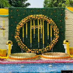 I love creating stunning poolside Haldi setups. For this event, I designed a circular marigold floral backdrop against a lush green wall, complete with traditional brass urlis, making it a perfect blend of modern and classic Haldi decor.