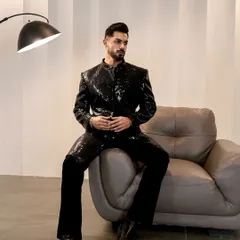 This black sequin jacket offers a contemporary take on festive dressing. It's a versatile piece that combines the structure of a jacket with the celebratory feel of traditional embellishments.