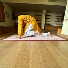 This image shows the forward fold in a variation of Cat-Cow, emphasizing the deep flexion of the spine. This movement helps to release tension in the lower back and stretch the entire vertebral column.