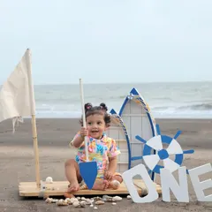 An adventurous first birthday shoot with a sailor theme right on the beach. The open sea, sand, and our custom boat props create a perfect setting for capturing your little explorer's special day.