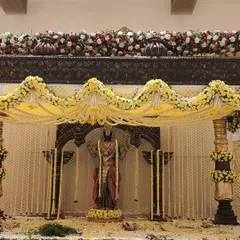 A full view of a traditional mandap I designed, centered around a large statue of Lord Balaji. The structure is decorated with extensive garlands of white tuberose and yellow flowers.