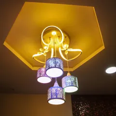 A whimsical and decorative ceiling light fixture with intricate, laser-cut shades that cast beautiful patterns.