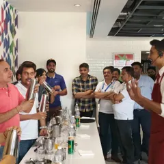 Guests at a corporate workshop trying their hand at shaking their own cocktails. It's a great team-building exercise that's both fun and rewarding.