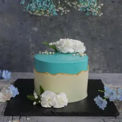 Simple elegance is always in style. This fault line cake combines a clean white base with a vibrant turquoise top, accented with delicate white carnations for a sophisticated look.