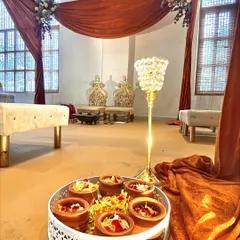 A detail shot showing traditional elements placed near the mandap, including earthen pots on a decorative tray, blending cultural rituals with our elegant decor.