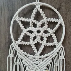 A detailed view of the central star pattern in my dreamcatcher, crafted from natural off-white cotton cord for a classic bohemian look.