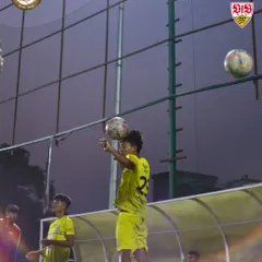 A young player practices his chest control during a night training session. We focus on mastering the fundamental skills from a young age.
