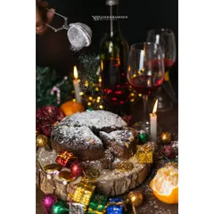 A festive Christmas cake scene, complete with the action of powdered sugar being dusted on top. This shot combines warm, celebratory lighting with a dynamic element to create a truly magical mood.