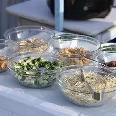 A clear view of the fresh and organized ingredients at one of our live food counters. We believe in transparency and quality, ensuring guests can see the fresh components that go into their meals.