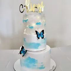 This three-tier 'cloud nine' cake was a dream to make for a Roka ceremony. The top tier is decorated with edible cotton candy to look like a cloud, with delicate blue butterflies adding a touch of magic.