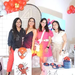 The party crew assembles for a Spiderman-themed birthday. I make sure the decorations, from the cake table to the character cutouts, are on point for an immersive experience.