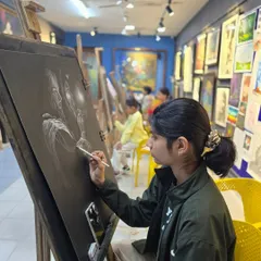 A student works on her charcoal drawing during a busy class. Our studio is always buzzing with creative energy, with easels set up for everyone to work comfortably.