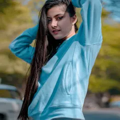 A clear, beautifully lit portrait from the blue hoodie series, capturing a sweet and direct look from the model.