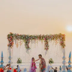 A sunset Varmala ceremony on a Goa beach. The golden light and the ocean backdrop make for an incredibly romantic setting, and we ensure we capture this magical atmosphere in our destination wedding photography.