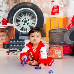 This little mechanic is taking his job very seriously. The garage-themed set, complete with tools and tires, is perfect for a child who loves to build and fix.