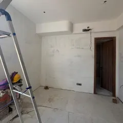 A smaller room under construction, with a ladder and tools hinting at the work underway. Every project, big or small, starts with this foundational phase of building and preparation.
