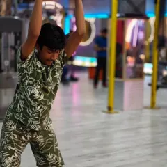 A member performing a plate ground-to-overhead lift. This is a full-body functional movement that builds explosive power and strength.