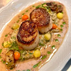 Perfectly seared scallops resting on a bed of colourful vegetables and a creamy sauce. This dish is a testament to our focus on high-quality seafood and balanced, elegant flavours.