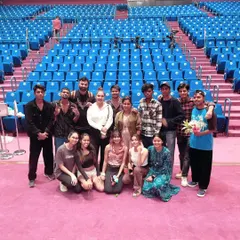 Our team posing for a group photo in a large auditorium after a successful event. We handle events of all sizes, from intimate gatherings to large-scale stage shows.